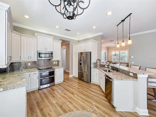 kitchen featuring visible vents, an inviting chandelier, a peninsula, a sink, and appliances with stainless steel finishes