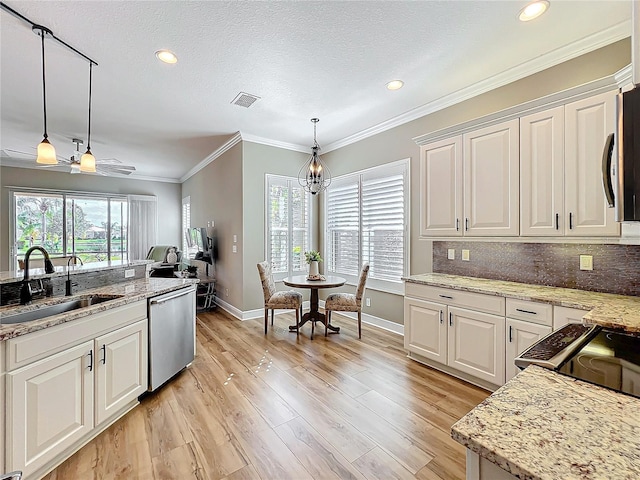 kitchen with visible vents, a sink, backsplash, light wood-style floors, and dishwasher