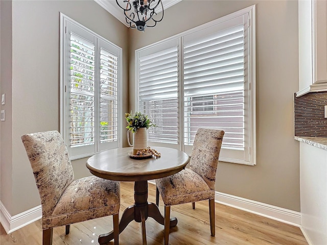 dining area with a notable chandelier, baseboards, and light wood-type flooring