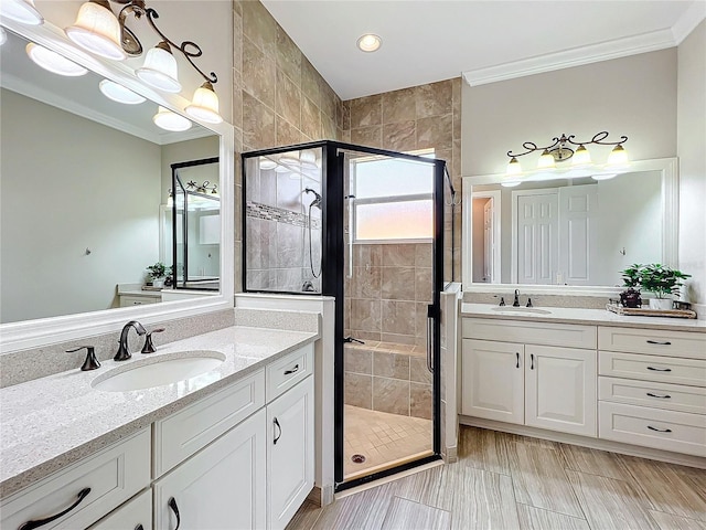 full bathroom featuring a shower stall, crown molding, and a sink