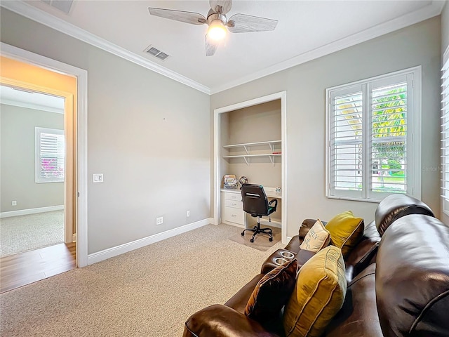 home office featuring visible vents, baseboards, ornamental molding, carpet flooring, and a ceiling fan