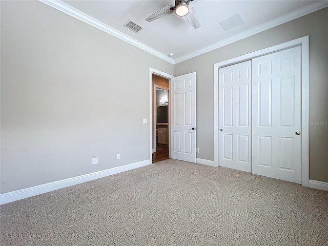 unfurnished bedroom featuring visible vents, ornamental molding, a closet, baseboards, and light colored carpet