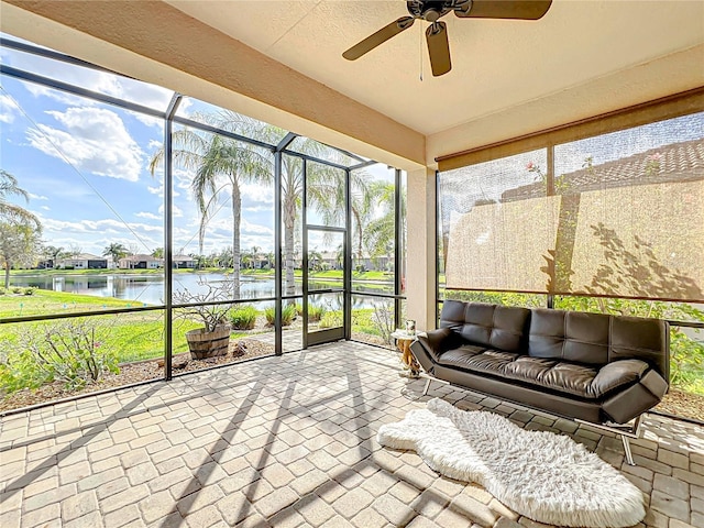 unfurnished sunroom featuring a water view and ceiling fan