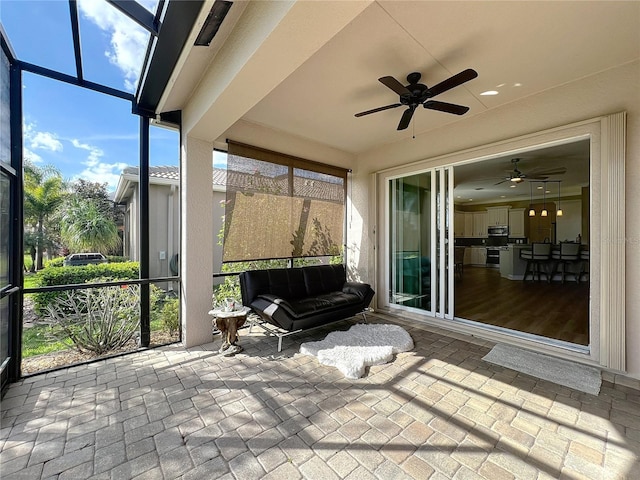 sunroom / solarium featuring a ceiling fan