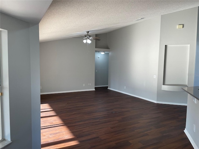 unfurnished room featuring dark wood-style floors, a textured ceiling, ceiling fan, and vaulted ceiling