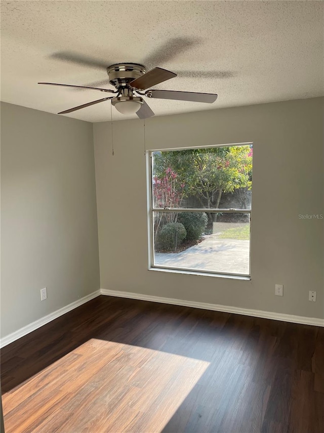 unfurnished room featuring a textured ceiling, wood finished floors, baseboards, and ceiling fan