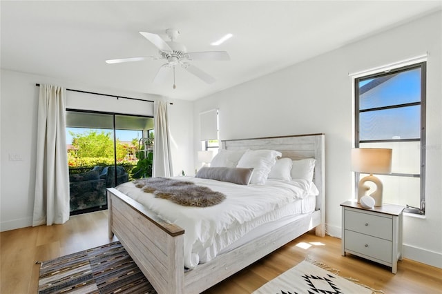 bedroom with a ceiling fan, access to exterior, wood finished floors, and baseboards