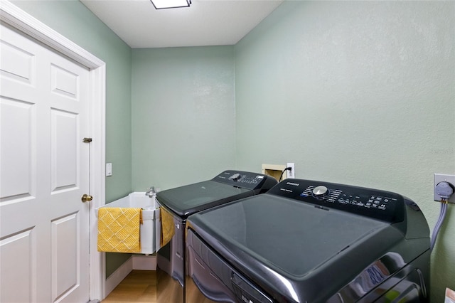 laundry room featuring washer and clothes dryer, laundry area, and light wood-type flooring