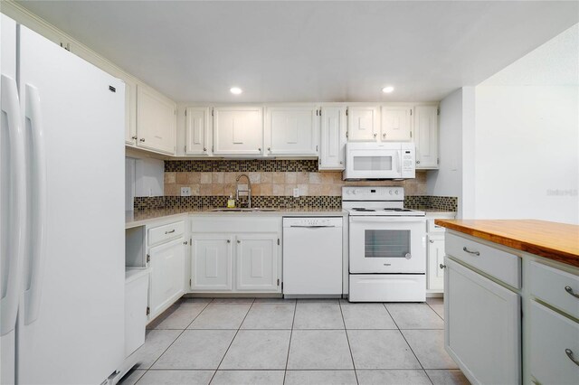 kitchen featuring decorative backsplash, recessed lighting, light tile patterned flooring, white appliances, and a sink