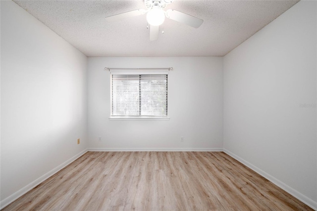 unfurnished room with a textured ceiling, wood finished floors, baseboards, and ceiling fan