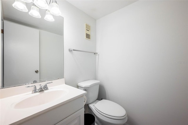 bathroom with vanity, toilet, and visible vents