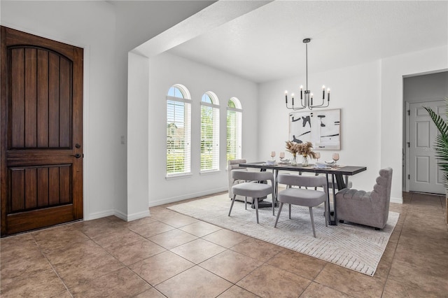 dining space with light tile patterned flooring, a notable chandelier, and baseboards