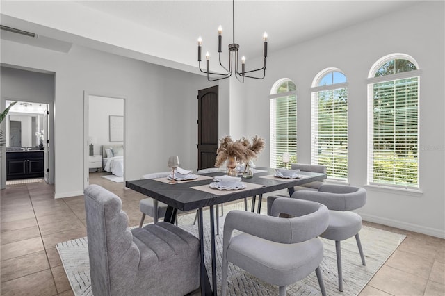 dining space with light tile patterned floors, baseboards, and an inviting chandelier