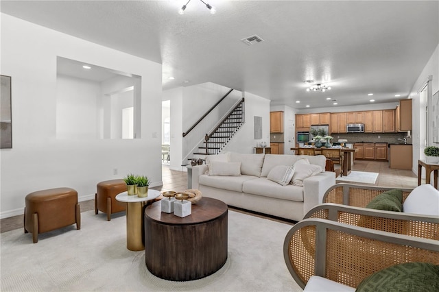 living area with visible vents, recessed lighting, light tile patterned floors, baseboards, and stairs