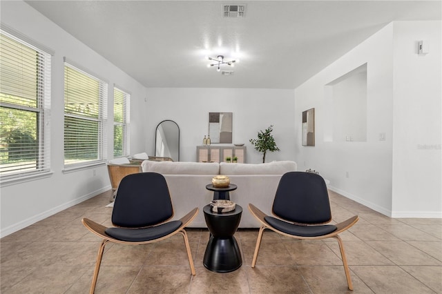 living room with light tile patterned floors, baseboards, and visible vents