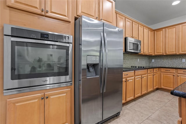 kitchen with dark stone countertops, tasteful backsplash, recessed lighting, appliances with stainless steel finishes, and light tile patterned flooring