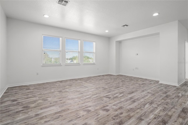 spare room featuring recessed lighting, visible vents, and wood finished floors