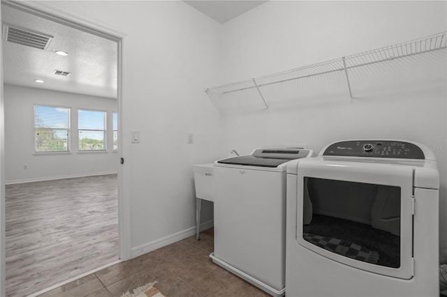 laundry area featuring tile patterned floors, visible vents, independent washer and dryer, and laundry area