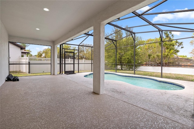 outdoor pool with glass enclosure, a patio, and fence