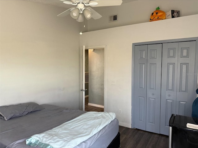 bedroom featuring visible vents, baseboards, ceiling fan, a closet, and dark wood-style flooring