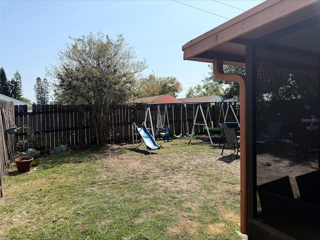 view of yard featuring a fenced backyard and a playground