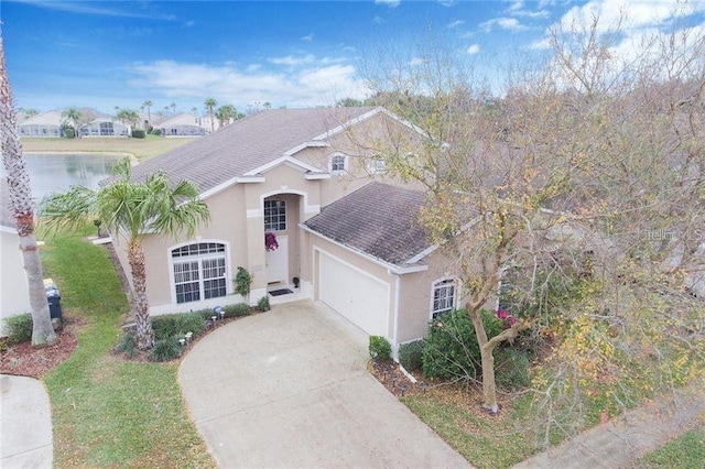 view of front of house with stucco siding, concrete driveway, a garage, and a shingled roof