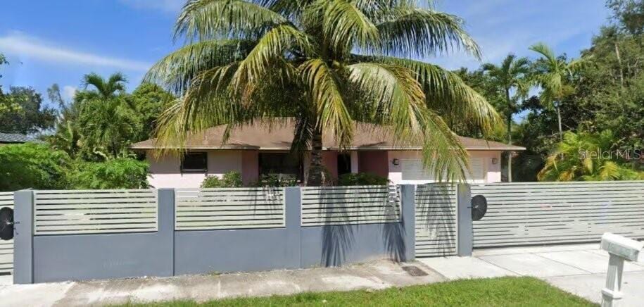 view of front of property featuring a fenced front yard, stucco siding, and a gate