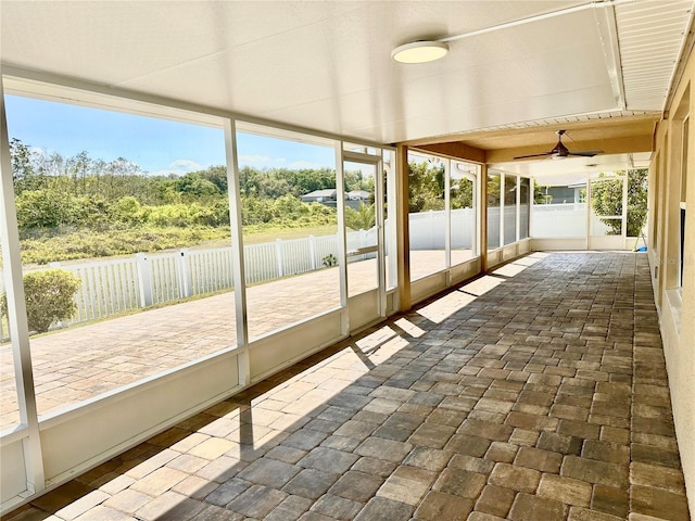 unfurnished sunroom with ceiling fan