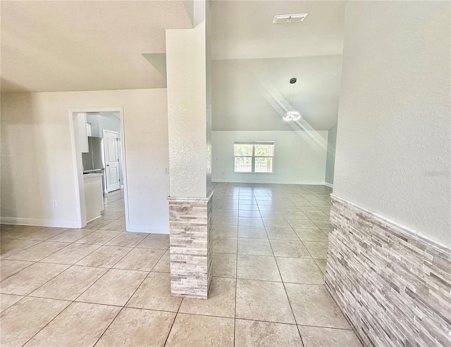 additional living space featuring light tile patterned floors, baseboards, and visible vents