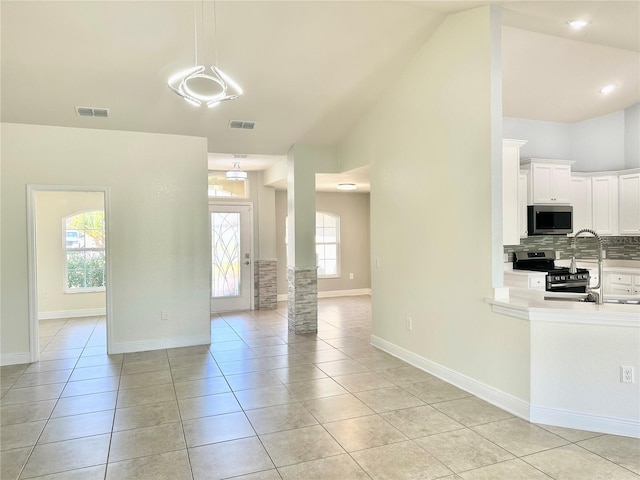 unfurnished living room featuring light tile patterned flooring, baseboards, and visible vents