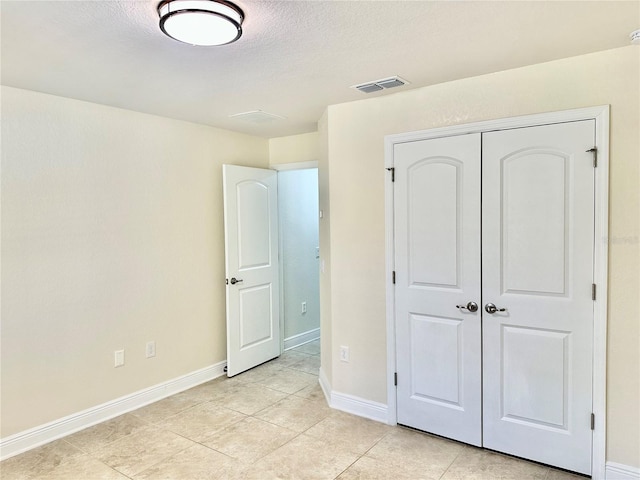 unfurnished bedroom featuring a closet, visible vents, and baseboards