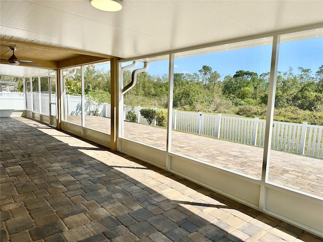 unfurnished sunroom featuring a healthy amount of sunlight and a ceiling fan