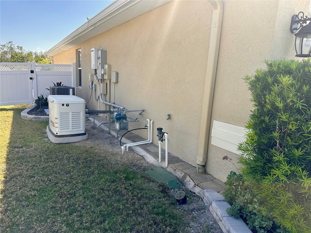 exterior space featuring central AC unit, stucco siding, a yard, and fence