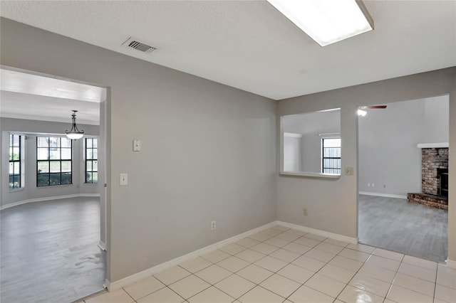 unfurnished living room featuring light tile patterned floors, visible vents, baseboards, and ceiling fan