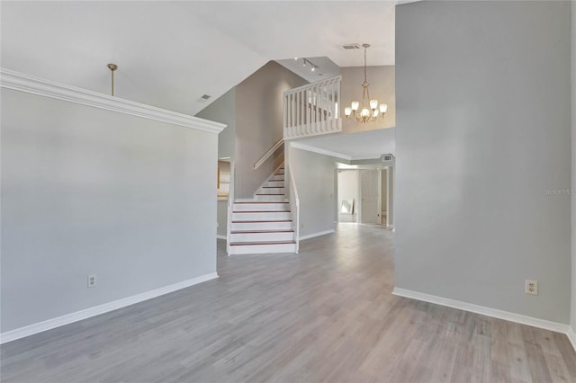 unfurnished living room featuring stairs, wood finished floors, baseboards, and a chandelier