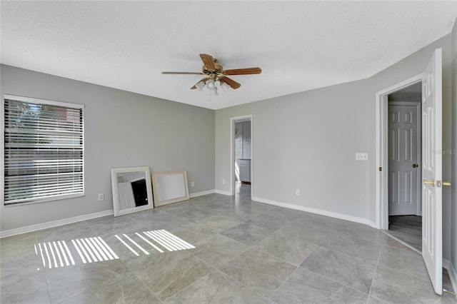 unfurnished living room with a textured ceiling, baseboards, and ceiling fan