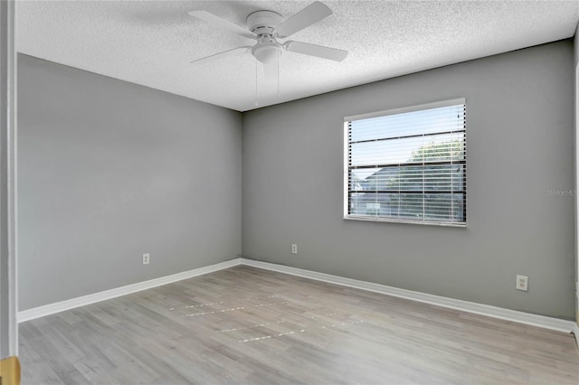 unfurnished room featuring wood finished floors, a ceiling fan, baseboards, and a textured ceiling