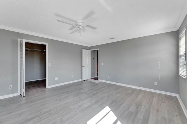 unfurnished bedroom featuring crown molding, wood finished floors, and baseboards