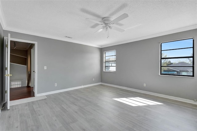 unfurnished room with wood finished floors, visible vents, ceiling fan, a textured ceiling, and crown molding