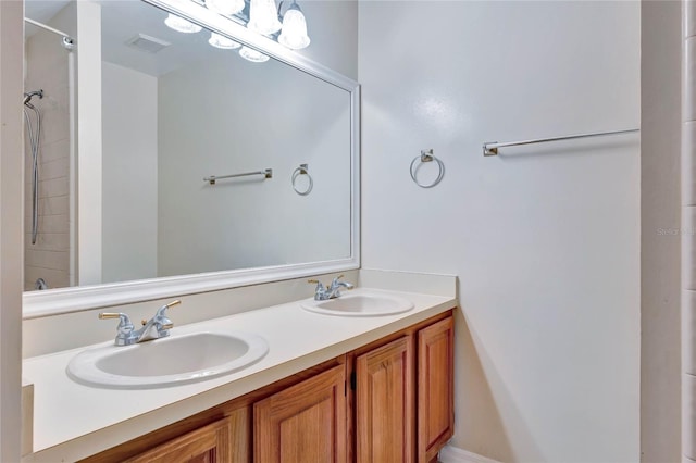 full bathroom featuring a sink, visible vents, a shower, and double vanity