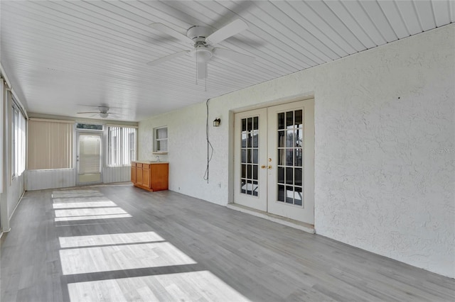 unfurnished sunroom with french doors and ceiling fan