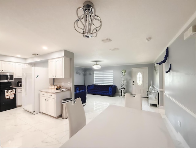 interior space featuring marble finish floor, black electric range oven, stainless steel microwave, white cabinetry, and white fridge with ice dispenser