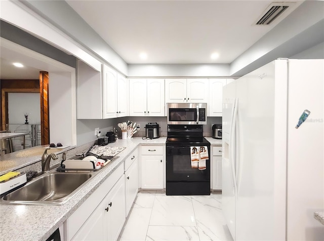 kitchen featuring visible vents, a sink, white refrigerator with ice dispenser, black range with electric stovetop, and stainless steel microwave