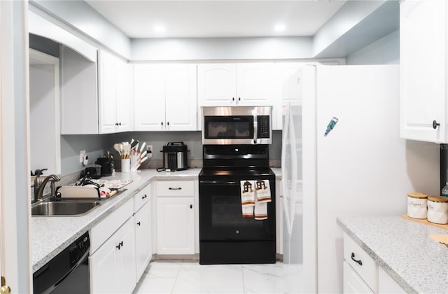 kitchen featuring a sink, black appliances, and white cabinetry