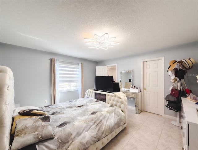 bedroom with light tile patterned floors and a textured ceiling