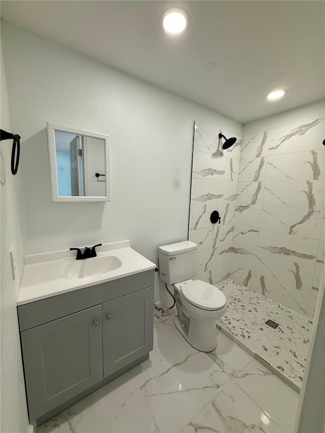 bathroom with a marble finish shower, toilet, recessed lighting, marble finish floor, and vanity