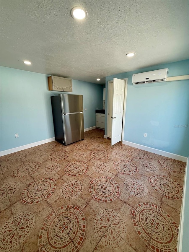 spare room with recessed lighting, baseboards, and an AC wall unit