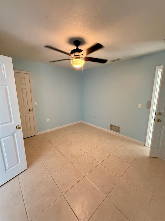 unfurnished room featuring light tile patterned floors, visible vents, baseboards, and ceiling fan