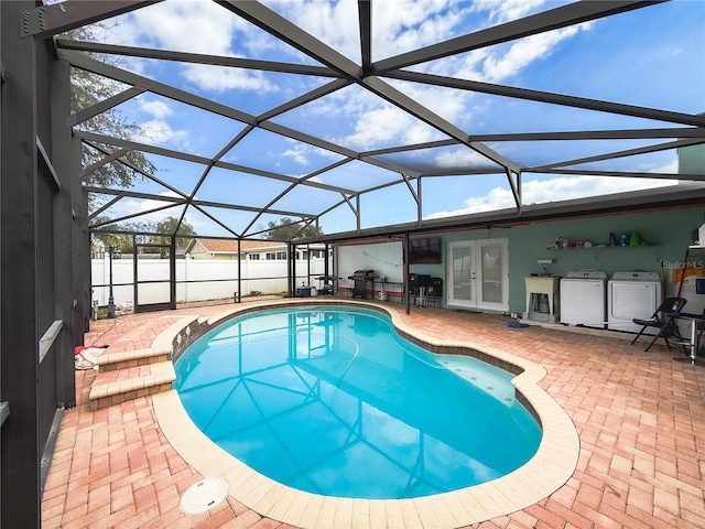 view of swimming pool featuring french doors, a patio, a fenced in pool, and washer / dryer