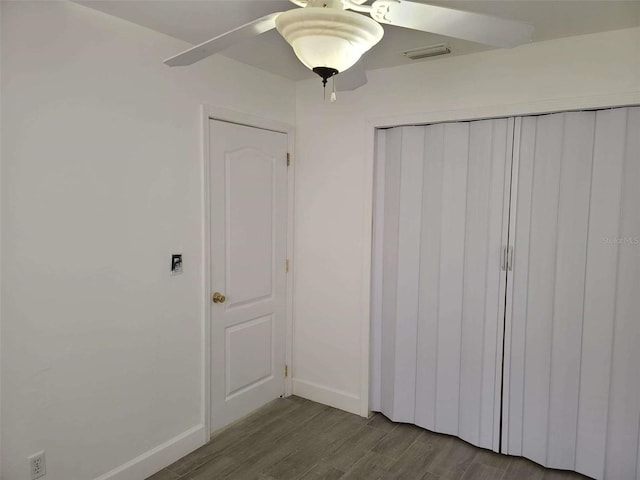 unfurnished bedroom featuring a closet, visible vents, wood finished floors, and baseboards